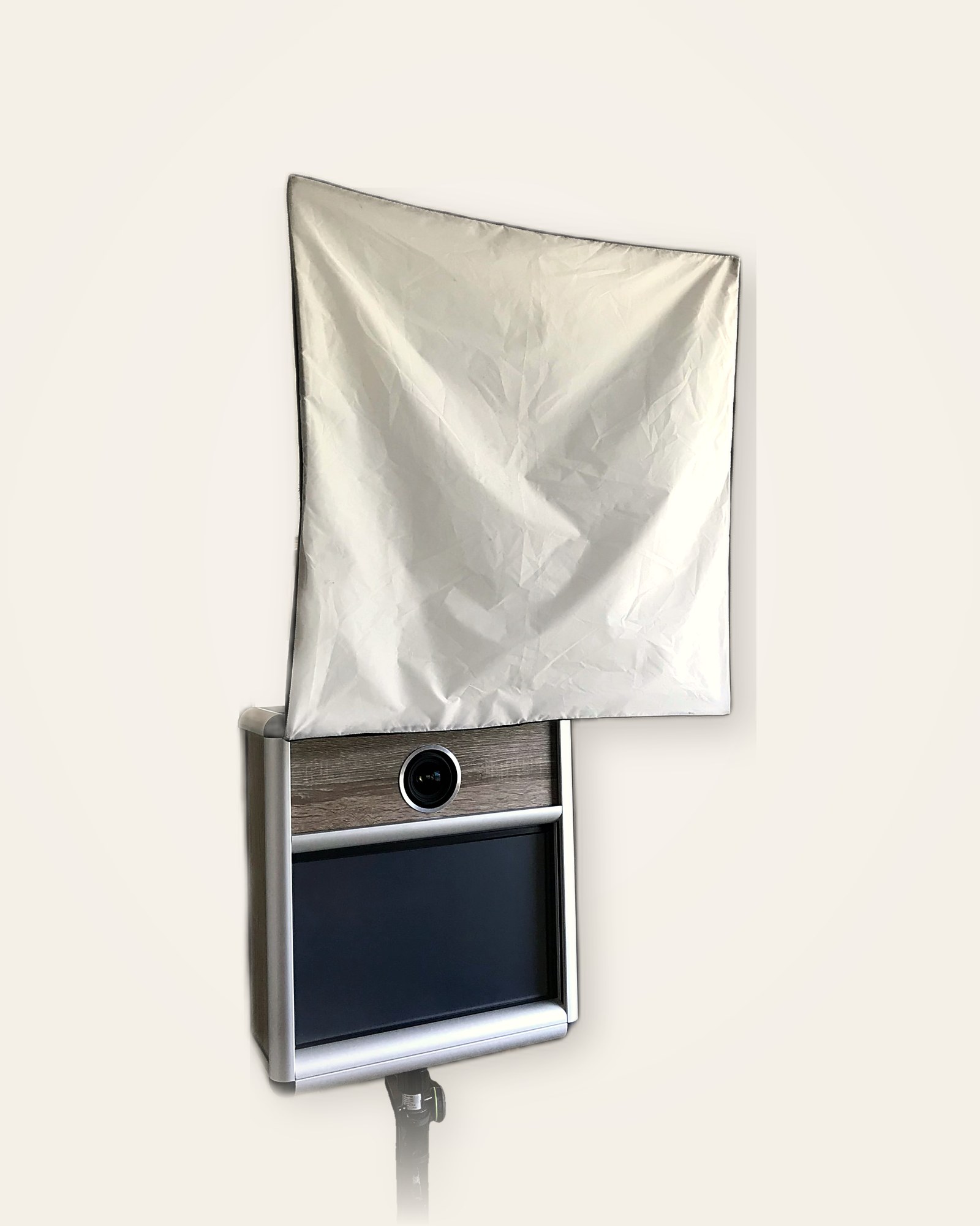 Fotobox mit Kamera, Bildschirm und Lichtdiffusor auf Stativ vor hellem Hintergrund